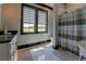 Bathroom featuring tiled walls, patterned shower curtain, and dual-pane window at 5187 Parkview Rd, Social Circle, GA 30025