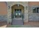 Close-up of a stone entryway featuring a stunning, arched double-door entrance with wreaths at 5187 Parkview Rd, Social Circle, GA 30025