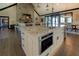 Open-concept kitchen boasts stone countertops and a kitchen island with stainless steel appliances at 5187 Parkview Rd, Social Circle, GA 30025