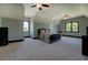 Spacious main bedroom with carpet, ceiling fan, and decorative windows at 5187 Parkview Rd, Social Circle, GA 30025