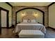 Stunning bedroom features a stone arch, tray ceilings, and beautiful flooring at 5187 Parkview Rd, Social Circle, GA 30025