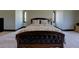 A tufted bed in a spacious carpeted main bedroom with two arched windows at 5187 Parkview Rd, Social Circle, GA 30025