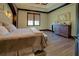 Relaxing main bedroom featuring tray ceilings, wood floors, and a full sized bed at 5187 Parkview Rd, Social Circle, GA 30025