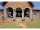 Cozy covered patio featuring stone arches and potted flowers at 5187 Parkview Rd, Social Circle, GA 30025