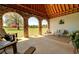 Covered patio with stone archways, comfortable seating, and views of the lush lawn at 5187 Parkview Rd, Social Circle, GA 30025