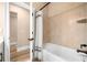 Well-lit bathroom featuring a bathtub with a shower curtain and tile surround with shelving at 530 Payne Rd, Woodstock, GA 30188