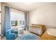 Bright Bedroom with a wooden crib, plush blue chair, and alphabet rug, ideal for a playful space at 530 Payne Rd, Woodstock, GA 30188