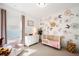 Charming Bedroom featuring floral wallpaper, a crib, and pink accents for a cozy and inviting space at 530 Payne Rd, Woodstock, GA 30188