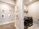 Laundry room with modern washer and dryer, framed photos and shelving for detergents at 530 Payne Rd, Woodstock, GA 30188