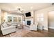 Bright living room with a stone fireplace, ceiling fan, and large windows overlooking the backyard at 530 Payne Rd, Woodstock, GA 30188