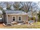 The backyard features a stone patio with outdoor seating and dining, surrounded by green grass at 1045 Moreland Se Ave, Atlanta, GA 30316