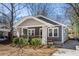 Charming bungalow featuring a covered front porch, gray siding, and landscaped yard at 1045 Moreland Se Ave, Atlanta, GA 30316
