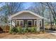 Charming home featuring a gray brick foundation and shingle siding, complemented by lush front yard landscaping at 1045 Moreland Se Ave, Atlanta, GA 30316