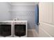 Functional laundry area equipped with a washer, dryer, shelving, and ironing board at 1045 Moreland Se Ave, Atlanta, GA 30316