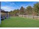 Spacious backyard with a green lawn, wooden fence, and a pergola-covered patio area at 3184 Elmwood Ct, Atlanta, GA 30349