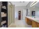 Bathroom featuring a shower with glass door, double sinks, and cabinet storage at 3184 Elmwood Ct, Atlanta, GA 30349