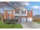 Charming two-story brick home with red shutters and a two-car garage, all under a clear blue sky at 3184 Elmwood Ct, Atlanta, GA 30349