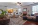 Cozy living room with hardwood floors, fireplace, a plush sectional sofa, and large windows providing natural light at 3184 Elmwood Ct, Atlanta, GA 30349