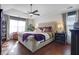 The bright main bedroom features a tray ceiling, ceiling fan, and a large window at 3184 Elmwood Ct, Atlanta, GA 30349