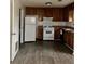 Kitchen with wood cabinets, white appliances, and wood-look vinyl flooring at 3628 Hopkins Ct, Powder Springs, GA 30127