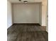 Empty room featuring dark wood-look vinyl flooring, white walls, and ceiling light at 3628 Hopkins Ct, Powder Springs, GA 30127