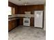 Functional kitchen with wooden cabinets, white appliances, and durable flooring, offering practicality and essential features at 3634 Hopkins Ct, Powder Springs, GA 30127