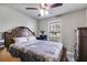 Neutral bedroom with a classic wood bed frame, plush bedding, and a side table with fresh flowers at 674 Fairview Dr, Dallas, GA 30157