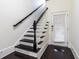 Elegant staircase with black and white accents leading to a door with blinds at 745 Fountainhead Ne Ln # 112, Atlanta, GA 30324