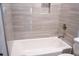 Clean bathroom with a tub, tiled walls, and a toilet, creating a fresh and modern space at 1395 Winburn Dr, East Point, GA 30344