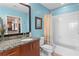 Bathroom featuring granite vanity, wood cabinetry, commode and shower-over-tub combination at 943 Peachtree Ne St # 1910, Atlanta, GA 30309