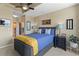 Comfortable bedroom featuring plush blue bedding, side tables, artwork, ceiling fan and attached bath at 943 Peachtree Ne St # 1910, Atlanta, GA 30309