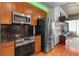 Modern kitchen with wood cabinets, stainless steel appliances, and sleek black backsplash at 943 Peachtree Ne St # 1910, Atlanta, GA 30309