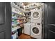 Well-stocked pantry featuring organized shelving, chest freezer and stacked washer and dryer units at 943 Peachtree Ne St # 1910, Atlanta, GA 30309