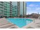 Outdoor pool with lounge chairs and lush landscaping with a building backdrop at 943 Peachtree Ne St # 1910, Atlanta, GA 30309