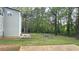 Spacious backyard featuring mature trees and concrete patio at 1276 Seattle Slew Ln, Norcross, GA 30093