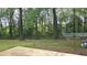 Lush backyard with mature trees, grassy area, and concrete patio at 1276 Seattle Slew Ln, Norcross, GA 30093