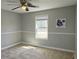 This cozy bedroom features neutral carpeting, a ceiling fan and ample natural light at 1276 Seattle Slew Ln, Norcross, GA 30093