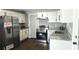 Updated kitchen features stainless steel appliances, white cabinets, granite counters, and dark wood-look flooring at 1276 Seattle Slew Ln, Norcross, GA 30093