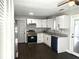 Bright, renovated kitchen featuring stainless appliances, white cabinets, granite counters, and dark wood-look flooring at 1276 Seattle Slew Ln, Norcross, GA 30093
