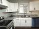 Well-lit kitchen featuring white cabinets, granite counters, stainless sink, and modern appliances at 1276 Seattle Slew Ln, Norcross, GA 30093