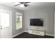 Living area featuring wood-look floors, a TV and entertainment center, and natural light from the window at 1276 Seattle Slew Ln, Norcross, GA 30093