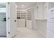 Walk-in closet featuring extensive custom shelving, a beverage refrigerator, and ample storage space at 1418 Waterford Green Dr, Marietta, GA 30068