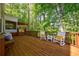 Inviting wooden deck offers serene views with rocking chairs and built-in benches at 1418 Waterford Green Dr, Marietta, GA 30068