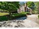 A large driveway leads to a well-maintained home surrounded by lush greenery at 1418 Waterford Green Dr, Marietta, GA 30068