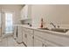 Functional laundry room with white cabinets, sink, counter space, and modern washer and dryer at 1418 Waterford Green Dr, Marietta, GA 30068