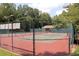 Fenced tennis court with well-maintained surface and nets, set in a wooded area at 1418 Waterford Green Dr, Marietta, GA 30068