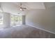 Spacious bedroom featuring a ceiling fan, neutral walls, plush carpet, and large windows at 2075 Ivy Ln, Union City, GA 30291