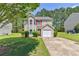 A lovely two-story home with neutral siding, neat landscaping, and a driveway, set on a green lawn at 2075 Ivy Ln, Union City, GA 30291