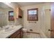 Bright bathroom features a shower-tub combo, built-in cabinet, and a window with wooden shutters at 5534 Blackhawk Dr, Acworth, GA 30102