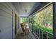 Inviting outdoor covered porch with wood flooring, railing, and a view of trees at 5534 Blackhawk Dr, Acworth, GA 30102
